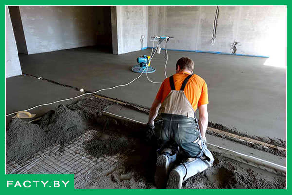 Мастер делает цементную стяжку